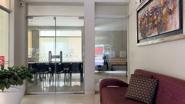 Interiores del Cacique Hotel: sala de reuniones vidriada vista desde el pasillo