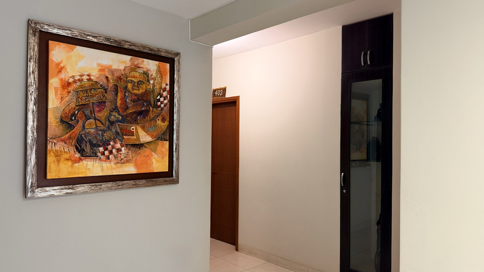 Pasillo interior del hotel con cuadro decorativo y puertas de habitaciones