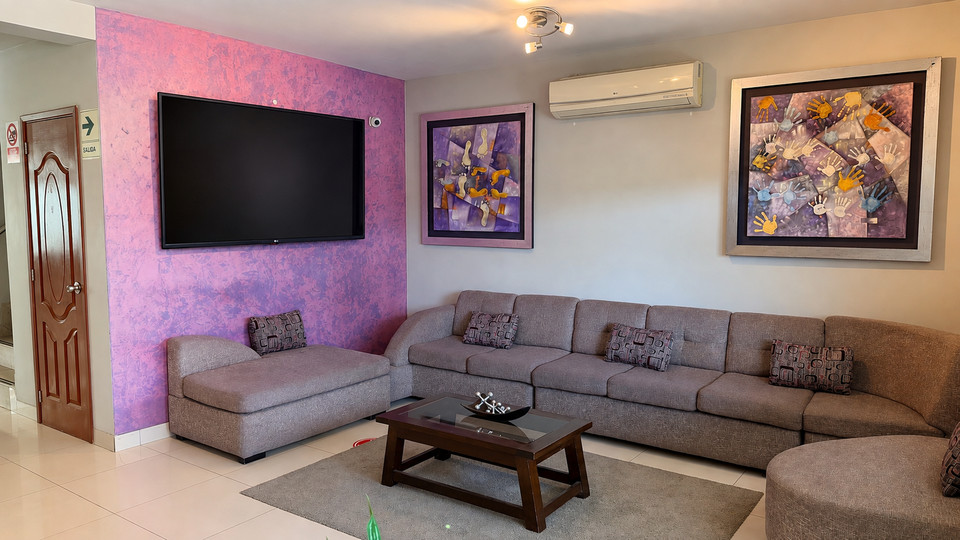 Sala de estar del lobby del Cacique Hotel, con televisor y sofá en L